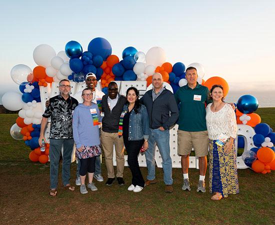 people posing by blue and orange balloons